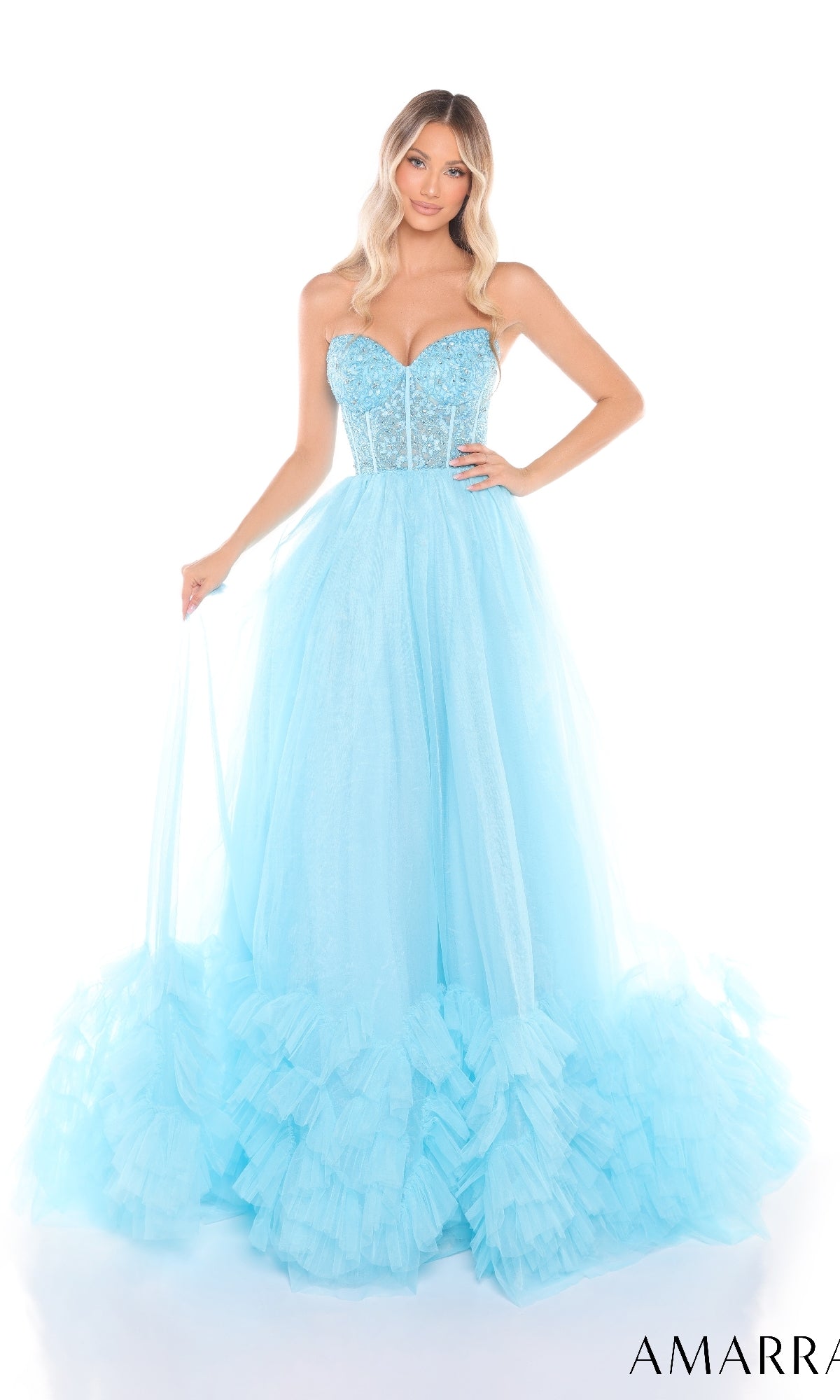 A woman wearing the Amarra 88339 Long Prom Dress, featuring a strapless, beaded corset bodice and a light blue tulle floor-length skirt with ruffled layers at the hem.
